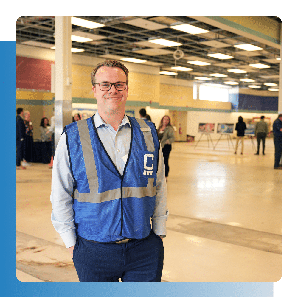 Smiling worker in a construction jacket representing IT-supported plastics and rubber manufacturing