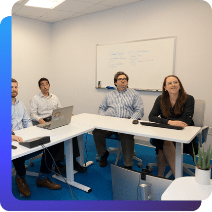Charles IT team members seated around a conference table during a collaborative meeting.
