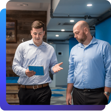 Two IT professionals discussing business strategy while reviewing information in an office setting.