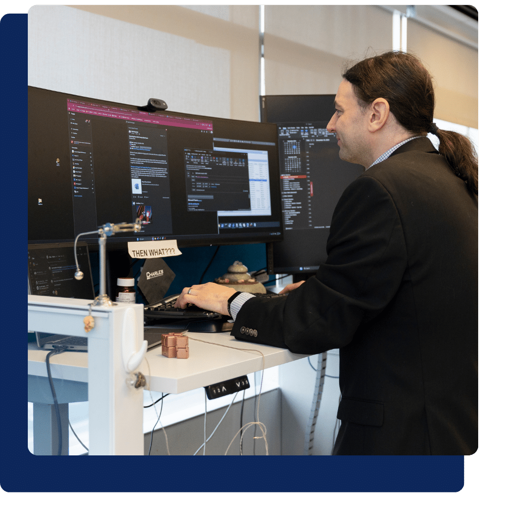 Charles IT engineer monitoring systems and IT infrastructure at a standing desk